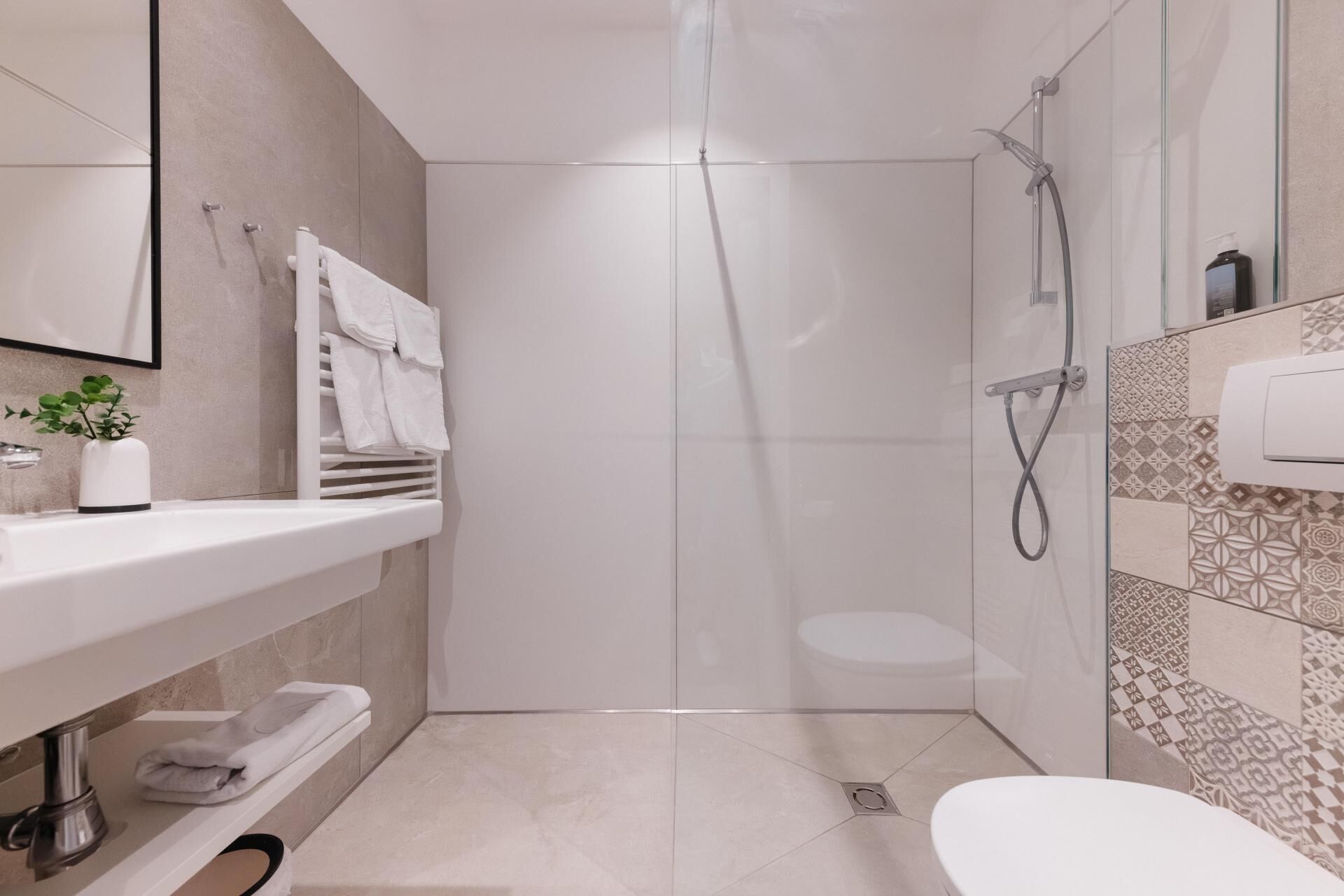 A modern bathroom with a shower, toilet, and sink.