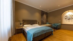 Une chambre d’hôtel moderne avec un grand lit, un petit bureau, une chaise et un élément décoratif mural.