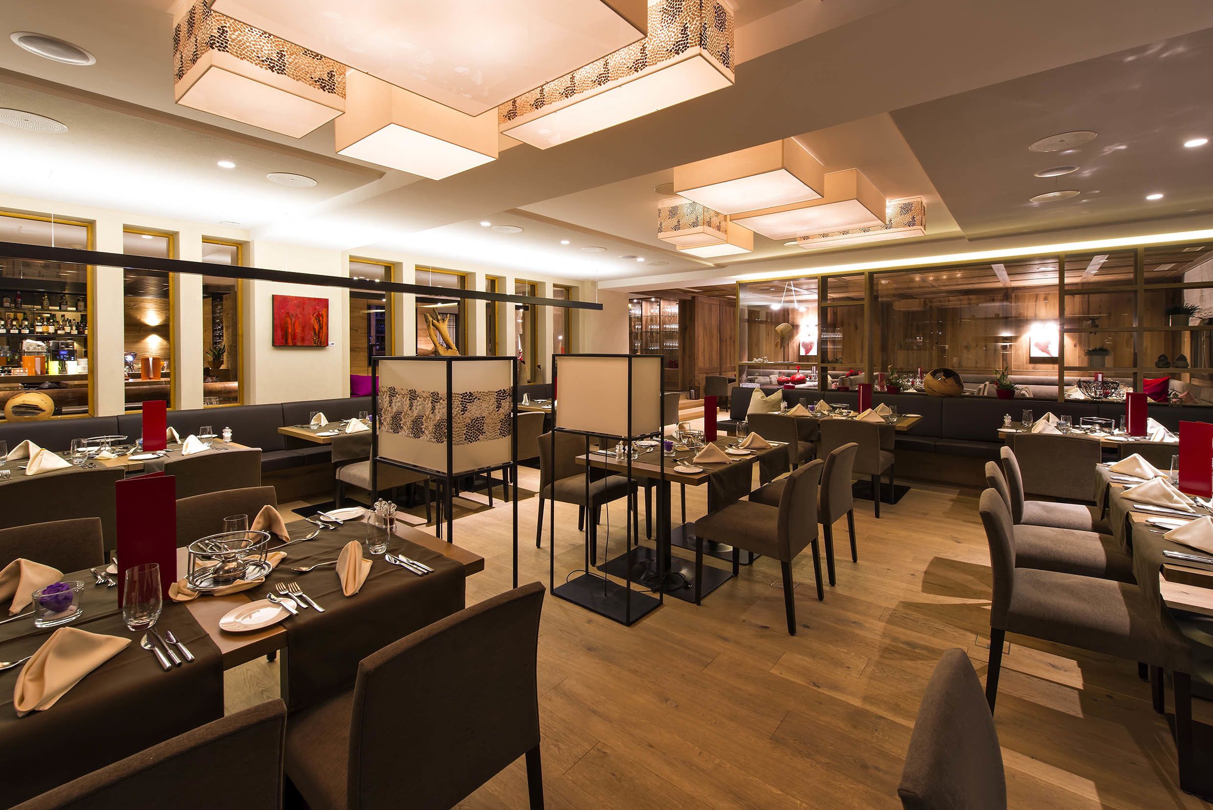 Un restaurante con varias mesas, sillas y una zona de bar.