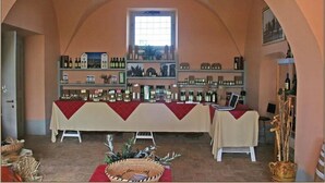 Una sala de degustación de vinos con una larga mesa cubierta con un paño rojo, rodeada de estantes llenos de botellas y copas de vino.