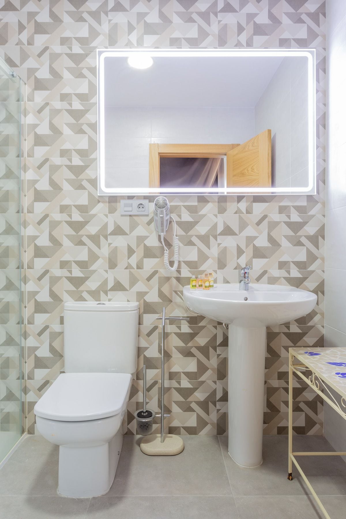 Une salle de bain avec des toilettes, un lavabo et un miroir.