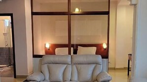 A modern living room with a beige sofa set, a glass coffee table, and a patterned rug. - C fun Addis Hotel (Addis Ababa)
