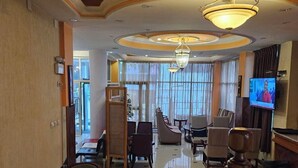 A spacious lobby with a high ceiling, elegant chandeliers, and a television screen. - C fun Addis Hotel (Addis Ababa)
