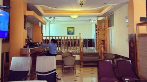 A hotel lobby with a central staircase, a reception desk, and seating areas. - C fun Addis Hotel (Addis Ababa)