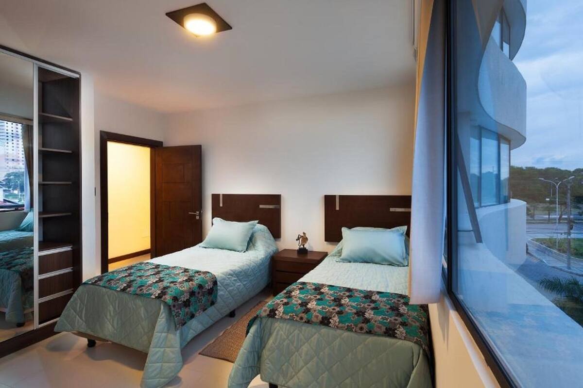 Un dormitorio con dos camas, un armario y una ventana con vistas.