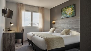 A modern hotel room with a large bed, a desk, and a TV mounted on the wall. - Hotel - Restaurant Crystal (Erstein)