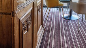 A room with a large wooden cabinet, a potted plant, and a dining area with chairs and a table. - Hotel - Restaurant Crystal (Erstein)