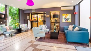 A modern lobby with a mix of seating options, including sofas and armchairs, a coffee table, and a reception desk. - Hotel - Restaurant Crystal (Erstein)