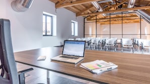 A modern conference room with a wooden ceiling, a laptop on a table, and a notebook. - Camplus Palermo (Palermo)