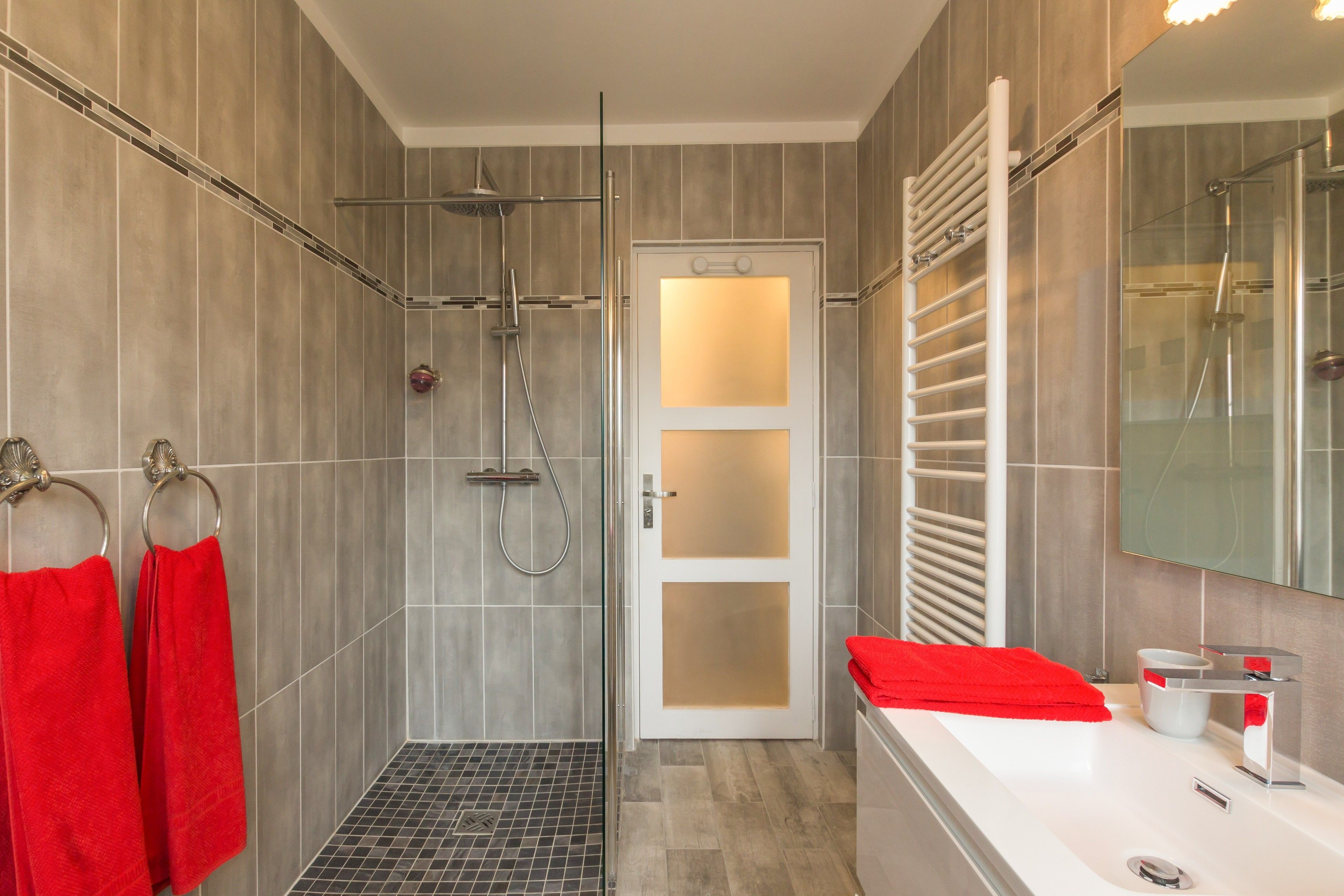 A modern bathroom with a shower, a sink, and a toilet.