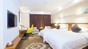 Una habitación de hotel con una cama grande, un escritorio con silla, un televisor y una ventana con cortinas.