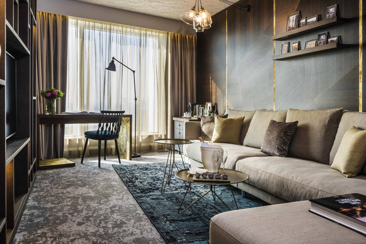 Un salon moderne comprenant un canapé, une table basse, un bureau et une bibliothèque.