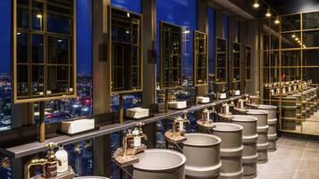 A hotel bathroom with multiple sinks, large mirrors, and a city view.