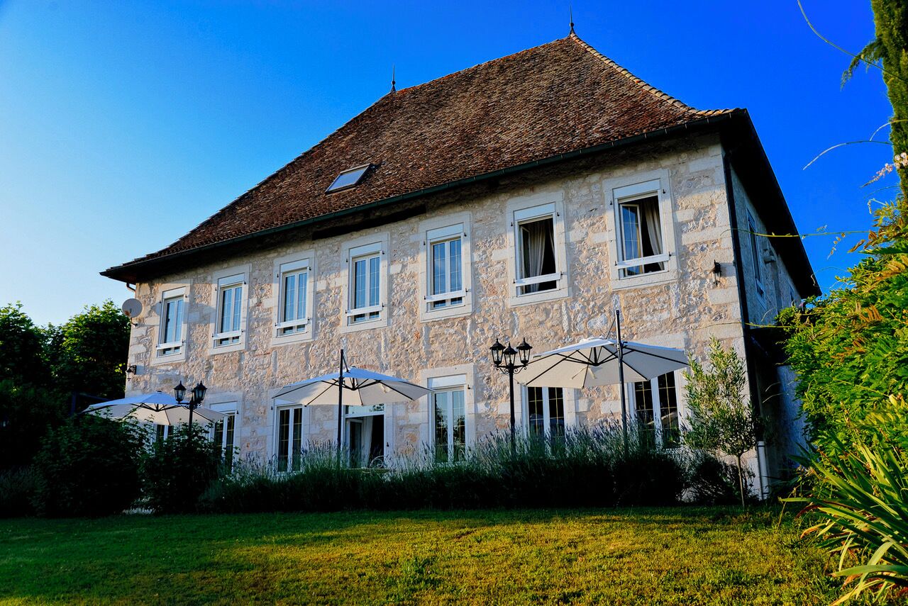 A large stone building with multiple windows and a sloped roof.