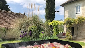 Una parrilla con carnes y verduras cocinándose al aire libre.