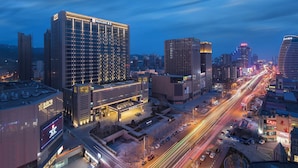 A high-rise hotel with multiple floors, a prominent sign, and a well-lit facade. - Holiday Inn Zhangjiakou Downtown by IHG (Zhangjiakou)
