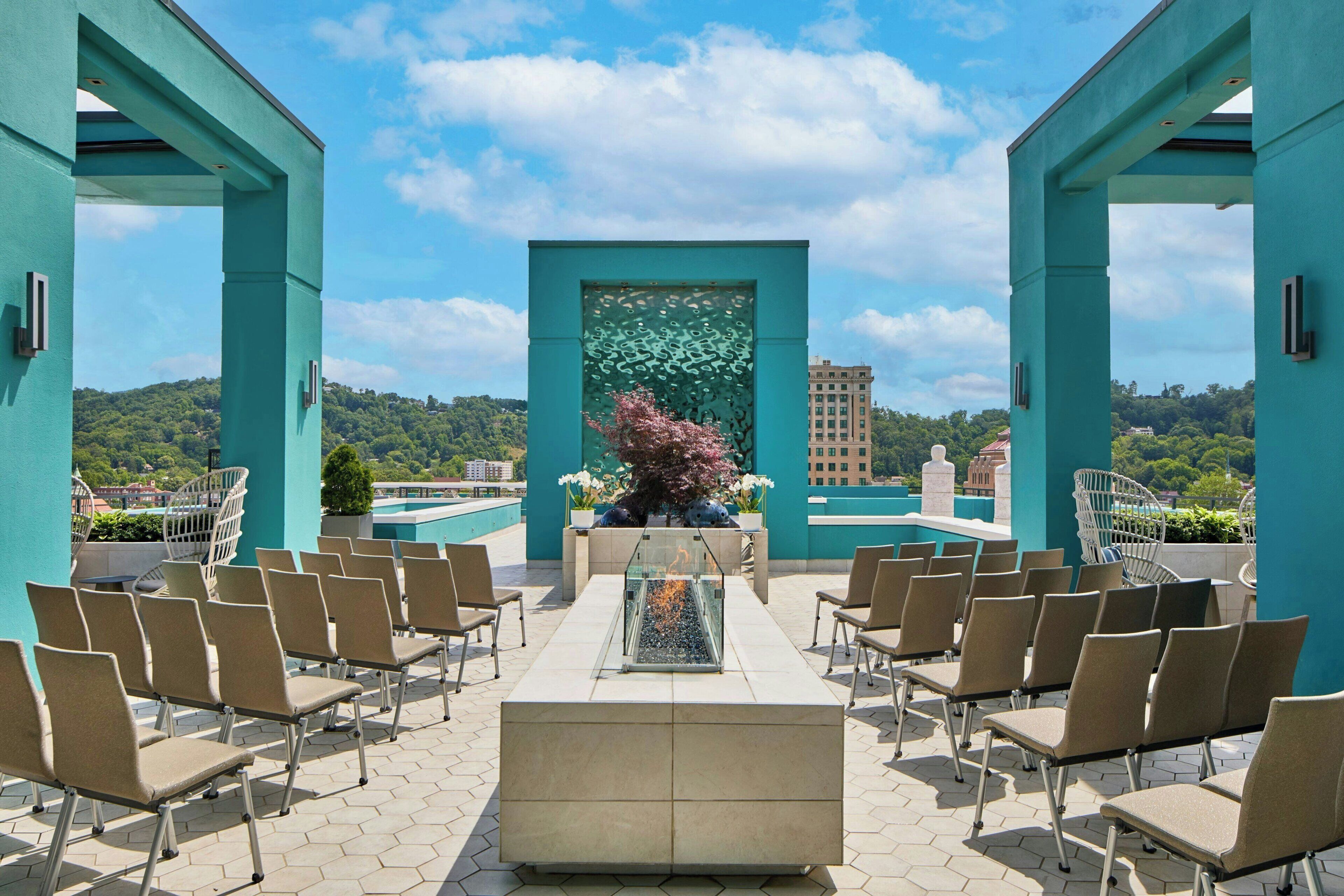 Una terraza en la azotea con zona de estar, una pared decorativa y vistas panorámicas de la ciudad.