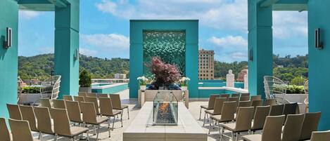 Una terraza en la azotea con zona de estar, una pared decorativa y vistas panorámicas de la ciudad.