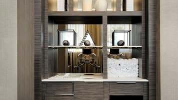 Un bagno moderno con un mobile lavabo integrato, porta asciugamani e un piccolo frigorifero.