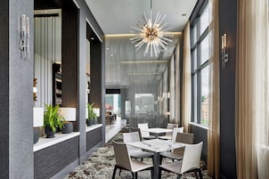A modern interior with a dining area, large windows, and a unique ceiling light fixture.