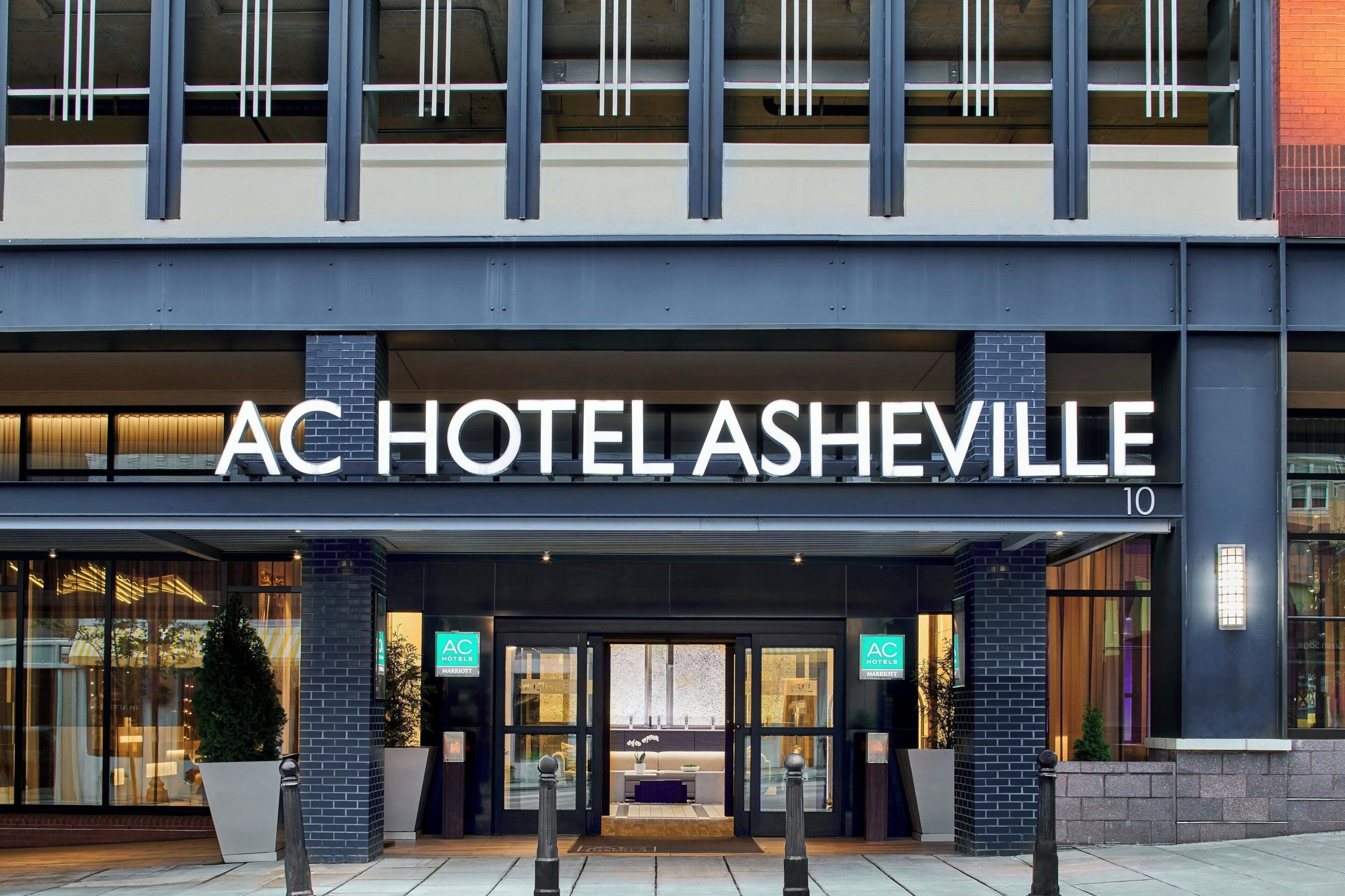 Das Äußere des AC Hotels Asheville mit moderner Fassade, großem Glas Eingang und dem sichtbaren Marriott Logo.