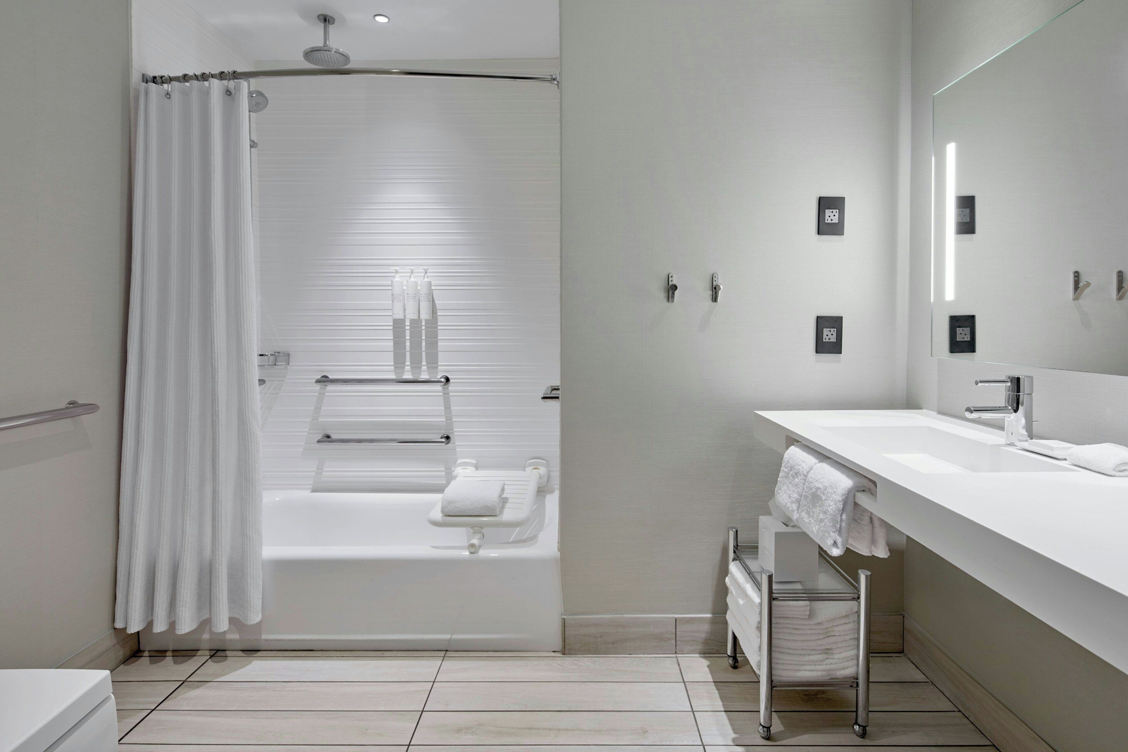 A modern bathroom with a bathtub, a shower, a toilet, and a sink.