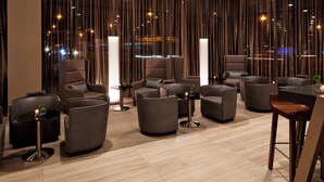 A modern lounge area with multiple seating options, including sofas and armchairs, arranged around a central coffee table.