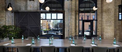 A conference room with a long table, chairs, water bottles, and glassware.