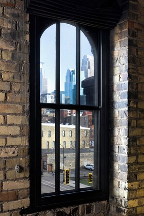 A window with a view of a cityscape, including buildings and a traffic light.