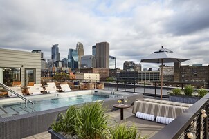 Una piscina al aire libre, sombrillas, sillones reclinables de piscina