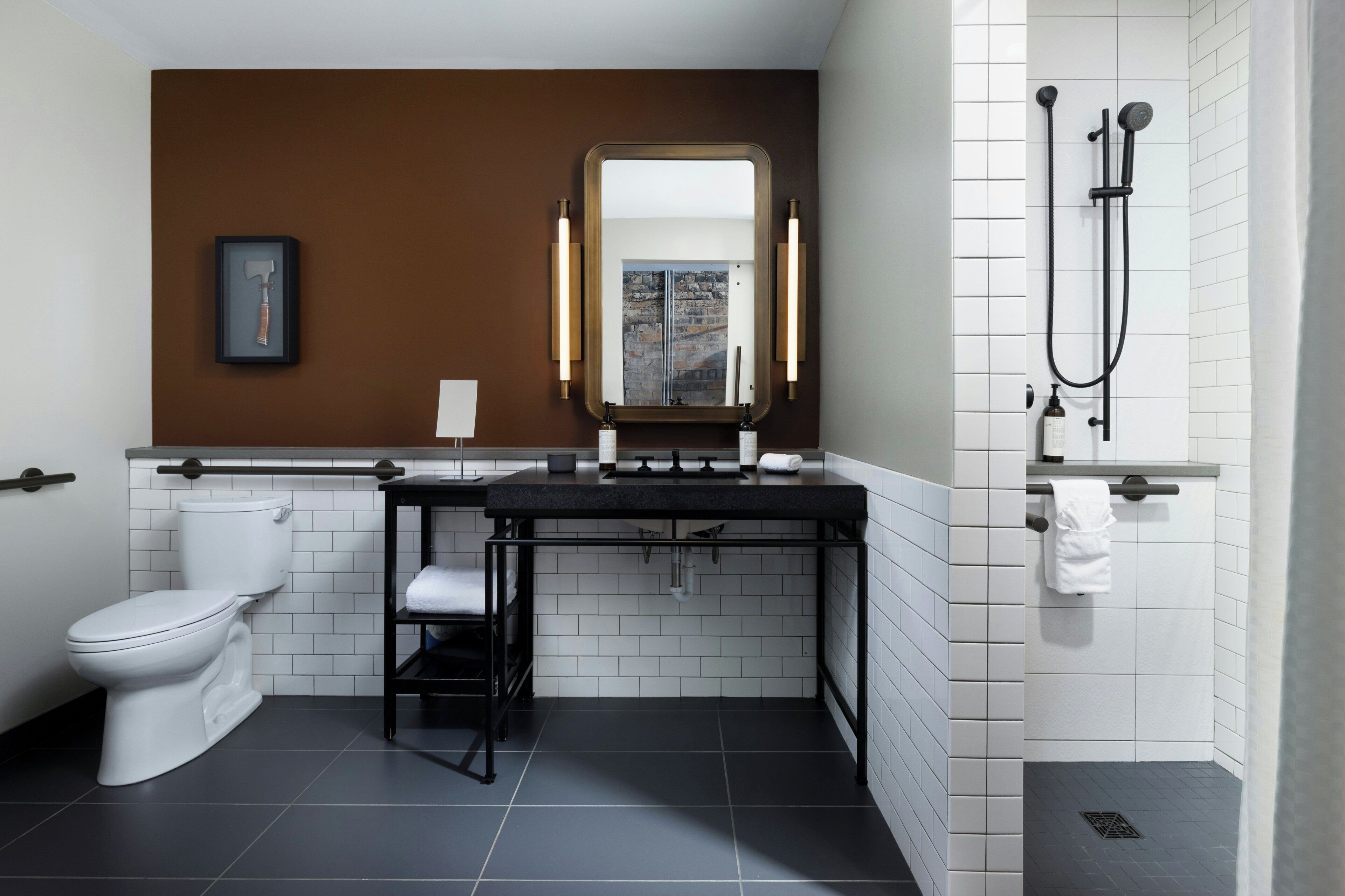A modern bathroom with a toilet, sink, mirror, and shower.