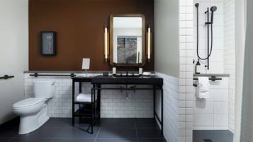 A modern bathroom with a toilet, sink, mirror, and shower.