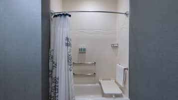 A bathroom with a bathtub, a shower curtain, a towel rack, and a small shelf with toiletries.