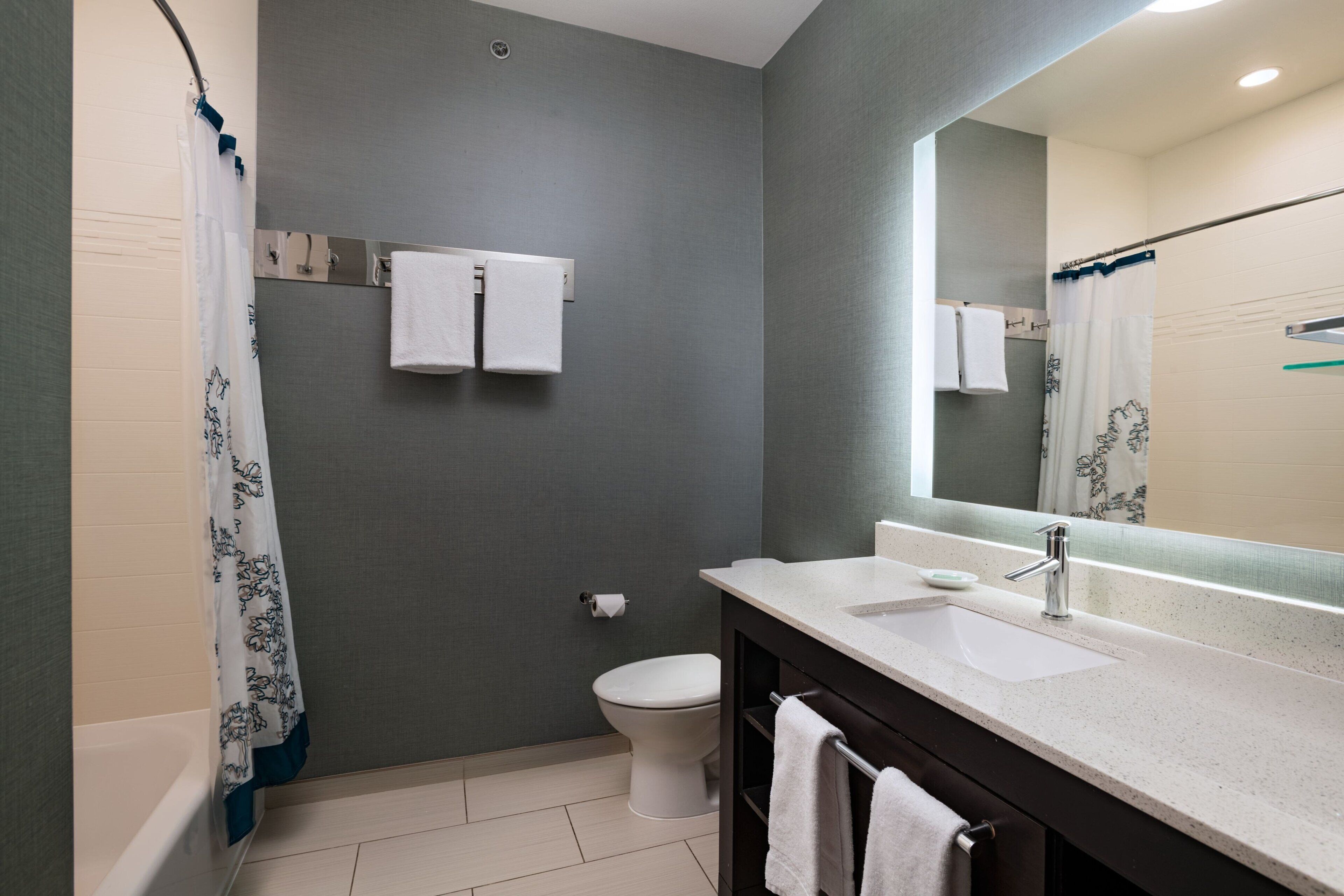 A modern bathroom with a bathtub, toilet, and sink.