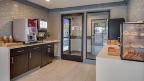 A modern kitchen with a coffee machine, a refrigerator, and a pastry display. - Americas Best Value Inn Hayward (Hayward)