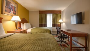 A hotel room with two beds, a desk, a chair, and a television on the wall. - Americas Best Value Inn Hayward (Hayward)