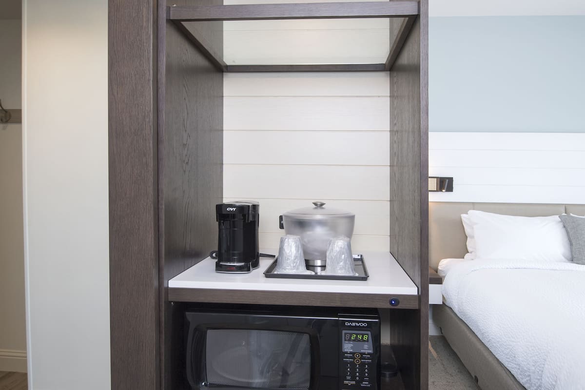 A compact kitchenette with a coffee maker, microwave, and small refrigerator.