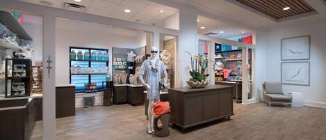 A modern interior with a mannequin, wooden flooring, and various home decor items on display.