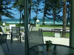 A seaside patio with outdoor seating, a view of the ocean, and a potted plant on a table. - Greenseaviewresort Bangsaphan (Bang Saphan)