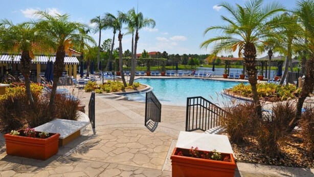 A pool area with palm trees, lounge chairs, and a covered seating area. - 211 Terra Verde House 7 Bedroom by Florida Star (Kissimmee)