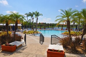 A pool area with palm trees, lounge chairs, and a covered seating area. - 211 Terra Verde House 7 Bedroom by Florida Star (Kissimmee)