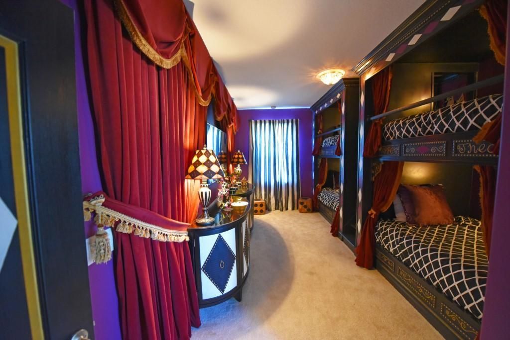 Una habitación con una cama litera, un escritorio con lámpara y una cortina.
