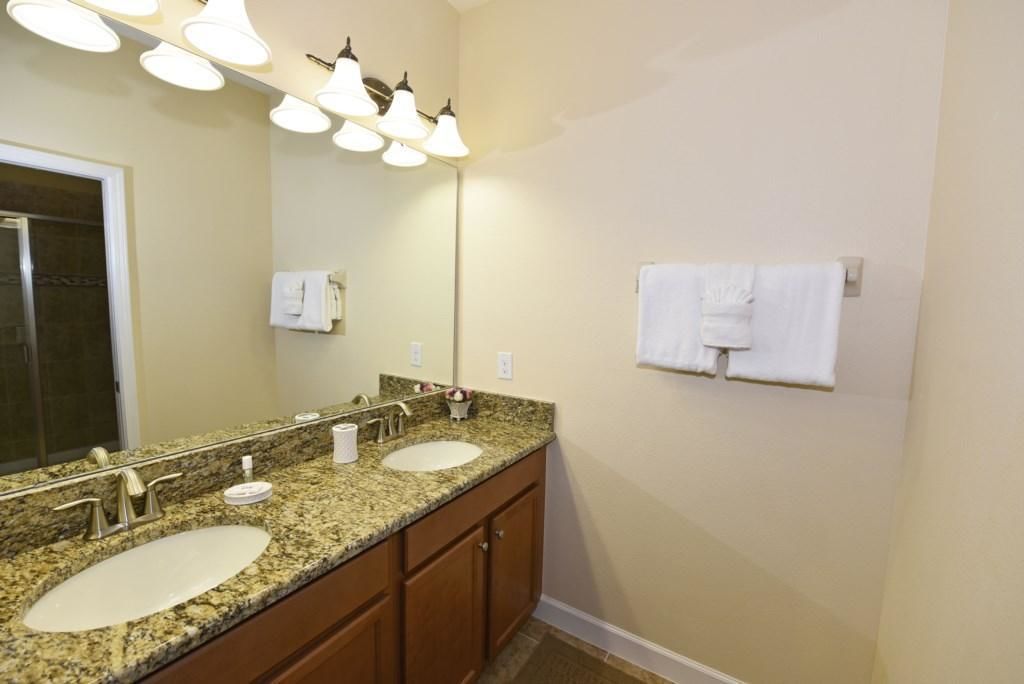 A bathroom with two sinks, a large mirror, and overhead lighting.
