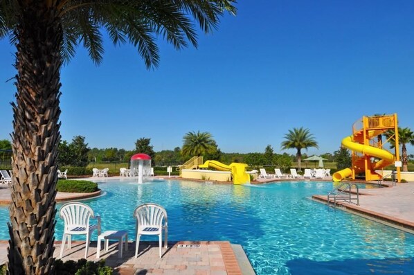 Relax by the pool surrounded by lounge chairs and a vibrant water slide.