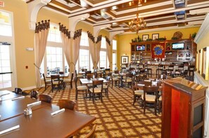 Experience the warm and inviting atmosphere of our lobby, featuring a high ceiling, chandelier, and comfortable seating areas.