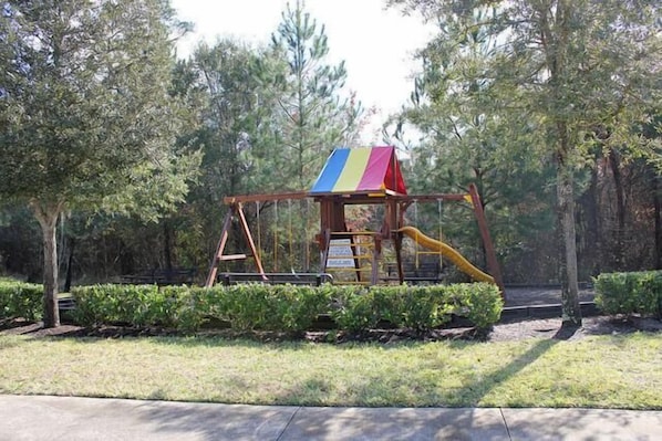 A playground with a colorful play structure and a slide.