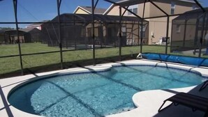 Una piscina con borde curvo, rodeada por un área techada.