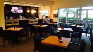 A restaurant with tables and chairs, a bar area with a TV, and large windows offering a view. - 3010 Encantada House 4 Bedroom by Florida Star (Kissimmee)