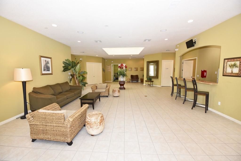 A spacious living area with a sofa, chairs, a coffee table, and a dining table with chairs.