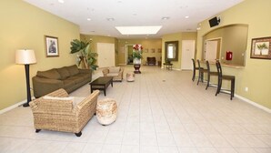 A spacious living area with a sofa, chairs, a coffee table, and a dining table with chairs. - 3125 VillaSol Townhome 4 Bedroom by Florida Star (Kissimmee)